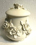 Delicada bomboniere em porcelana branca, com flores em alto relevo, medindo: 15 cm alt.