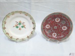2 pratos decorativos em porcelana, sendo um floral e um oriental. Medindo 18cm de diâmetro.
