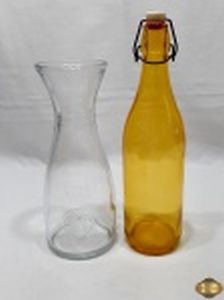 Lote composto de jarra em vidro incolor e garrafa em vidro amarelo. Medindo a garrafa 32,5cm de altura.