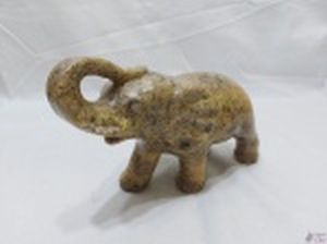 Escultura de elefante em pedra sabão. Medindo 25cm de comprimento x 17cm de altura. Com um bicado na presa e um na pata traseira.