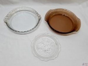 Lote de 2 travessas redondas em vidro temperado e 1 prato de doce em vidro moldado. Medindo a travessa marrom 25,5cm de diâmetro x 5cm de altura.