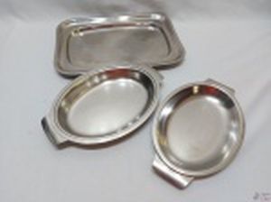 Lote de 3 travessas em aço inox, sendo 2 ovais e uma retangular. Medindo a retangular 36cm x 24cm.