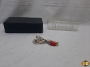 Lote diverso, composto de rabo quente, estojo e caixa para fita cassete. A caixa possui um rachadura. Medindo o estojo 23,5cm x 12,5cm x 7,5cm de altura.