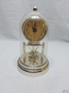Relógio quartz em plástico dourado com redoma incolor. Medindo 21,5cm de altura. Funcionando.