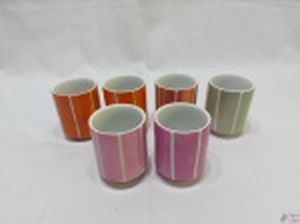 Jogo de 6 copinhos em porcelana colorida. Medindo 6,5cm de diâmetro x 8,5cm de altura.