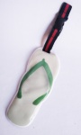 Etiqueta marcadora para mala com imagem de sandália de tiras, confeccionada em material plástico flexível e contendo no verso lugar para dados pessoais.