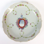 Covilhete em porcelana Cia. das Índias decoração Família Rosa com brasão pertencente ao serviço de Antônio José da Cruz Sobral. França, Séc. XVIII. 29 cm de diâmetro.  (Devido a fragilidade desse lote, seu envio só será realizado através de transportadora especializada). Chama-se Companhia das Índias a porcelana produzida na China por encomenda e com formas ou decoração ao gosto ocidental, transportada pelos navios das diversas Companhias das Índias - inglesa, francesa, holandesa, sueca etc. -, ativas entre os Sécs. XVII e começos do XIX. Nas porcelanas policromadas, ocorrem dois tipos principais de decoração: a Família Verde, surgida em fins do Séc. XVII sob o reinado do Imperador Kangxi (falecido em 1722), e a Família Rosa, caracterizada pela utilização de um esmalte de cor rósea, surgida mais ou menos em 1720 e que se estenderia por todo o reinado do Imperador Qianlong (1736-1795). Flores, pássaros e figuras humanas constituem a decoração preponderante nessas porcelanas. Além desses dois, existem, porém, outros tipos de decoração policromada, como por exemplo a Família Negra, que consiste na esmaltagem sobre fundo negro; a Café com Leite, na cor castanha, também chamada porcelana de Batávia porque era exportada através do porto de Batávia, em Java; e o Imari chinês, cuja decoração imita as porcelanas japonesas produzidas em Arita, na província de Hizen. Inúmeros serviços de jantar ou de chá e café em porcelana Companhia das Índias foram encomendados por nobres ingleses, franceses, alemães, holandeses, portugueses etc. e exibem suas armas ou brasões. De notar que os portugueses foram os primeiros europeus a encomendar à China peças de porcelana exibindo suas armas, sendo que as mais antigas remontam ao reinado do Imperador Zhengde (1506-1521), da Dinastia Ming.