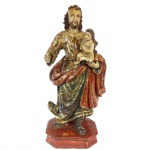 Imagem em madeira policromada e dourada representando São José de Botas com menino. 50 cm de altura.
