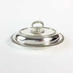 Legumeira com tampa em metal nobre espessurado a prata, contrastada. Inglaterra. Séc. XIX. (Pequena). 11 x 24 x 18 cm.