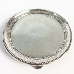 Salva em prata batida, repuxada e perolada de estilo e época D. Maria I. Brasil. 22 cm de diâmetro.