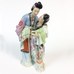 Escultura em porcelana policromada representando figuras femininas orientais. Marcas no verso. China, Princípio do Séc. XX.  29,5 cm de altura. (Devido a fragilidade desse lote, seu envio só será realizado através de transportadora especializada).