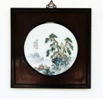 Placa em porcelana policromada decorada com paisagens e ideogramas. Moldura em madeira com alça em bronze. China, princípio do Séc. XX. Placa 30 cm e moldura 44 x 44 cm. (Devido a fragilidade desse lote, seu envio só será realizado através de transportadora especializada).