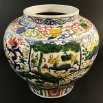 Vaso em porcelana policromada, decoração Wucai com suas reservas e representações de carpas e dragões. China, provavelmente Séc. XX. 31 x 32 cm. (Devido a fragilidade desse lote, seu envio só será realizado através de transportadora especializada).