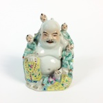 Escultura em porcelana policromada representando Buda com crianças. China, cerca de 1900. 14 cm de altura.