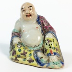 Escultura em porcelana policromada representando Buda. China, princípio do Séc. XX. Marcas no verso. 6 cm de altura.