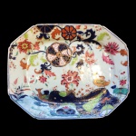 Rara travessa em porcelana Cia. das Índias decoração folha de chá. China, Qing, Qianlong (1736-1795), Séc. XVIII. (Devido a fragilidade desse lote, seu envio só será realizado através de transportadora especializada). Chama-se Companhia das Índias a porcelana produzida na China por encomenda e com formas ou decoração ao gosto ocidental, transportada pelos navios das diversas Companhias das Índias - inglesa, francesa, holandesa, sueca etc. -, ativas entre os Sécs. XVII e começos do XIX. Nas porcelanas policromadas, ocorrem dois tipos principais de decoração: a Família Verde, surgida em fins do Séc. XVII sob o reinado do Imperador Kangxi (falecido em 1722), e a Família Rosa, caracterizada pela utilização de um esmalte de cor rósea, surgida mais ou menos em 1720 e que se estenderia por todo o reinado do Imperador Qianlong (1736-1795). Flores, pássaros e figuras humanas constituem a decoração preponderante nessas porcelanas. Além desses dois, existem, porém, outros tipos de decoração policromada, como por exemplo a Família Negra, que consiste na esmaltagem sobre fundo negro; a Café com Leite, na cor castanha, também chamada porcelana de Batávia porque era exportada através do porto de Batávia, em Java; e o Imari chinês, cuja decoração imita as porcelanas japonesas produzidas em Arita, na província de Hizen. Inúmeros serviços de jantar ou de chá e café em porcelana Companhia das Índias foram encomendados por nobres ingleses, franceses, alemães, holandeses, portugueses etc. e exibem suas armas ou brasões. De notar que os portugueses foram os primeiros europeus a encomendar à China peças de porcelana exibindo suas armas, sendo que as mais antigas remontam ao reinado do Imperador Zhengde (1506-1521), da Dinastia Ming.30 X 38 cm.