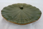 Grande prato redondo estilo medalhão em faiança ao gosto português, na cor verde, representando grande folha aquática com sapo. Med. 31 cm diâmetro.