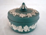 WEDGWOOD ENGLAND- Porta jóia em porcelana biscuit inglês no tom verde, pega da tampa no formato de pinha,com marca da manufatura Wedgwood na base. . Decorados com uvas e folhas de parreira em relevo. Marcado a crivo na base. Inglaterra, meados do séc. XX. Med. 6 x 8 cm.