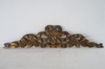 Talha confeccionada em madeir , ricamente esculpida com laçarotes e patinada em dourado. Med. 15 x 65 cm.