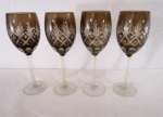 Conjunto com quatro taças para vinho em cristal fumê, apresentando rico trabalho de lapidação ao gosto overlay, haste longa e lisa.  Med.: 22 cm.