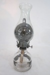 Antigo lampião à querosene em vidro prensado translúcido com guarnições em ferro na cor grafite. Med.: 31 cm.