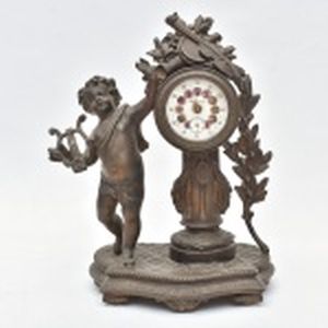 Relógio em petit bronze com alegorias à música, mostrador do relógio em esmalte.(pequenos defeitos) marca Cyma. Altura 25 cm.