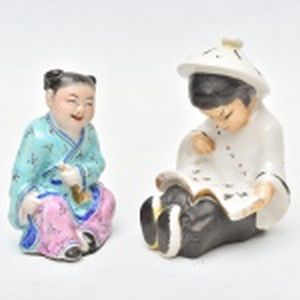 Duas estatuetas em porcelana chinesa: Menino lendo e o outro com corneta rindo. Altura 10 cm.