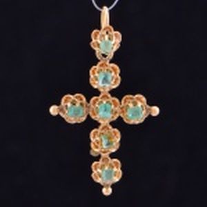 Cruz pingente em ouro 18 k, cravada com 7 esmeraldas em estilo Barroco. Peso 3,3 gramas. 4 cm.