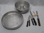 Lote diverso, composto de tabuleiro redondo, forma de bolo, 5 facas e 1 saca rolha. Medindo o tabuleiro em alumínio 29,5cm de diâmetro x 5,5cm de altura.