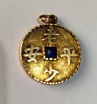 Pingente de Moeda  em ouro 18K  representando simolo chinês com safira ao centro . Mede:  2,3 cm - Peso: 4,48 g 
