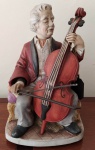 Enfeite Caixinha de música em resina pintada WACO  - Tocador de violancelo - Japonês - a pilha - não testado. Mede: 19x18x29 cm