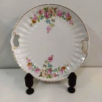 Belíssimo prato em porcelana com alças e desenhos florais . Marca: REAL. Mede: 27 cm-  Suporte não incluso