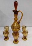 Antigo cojunto de licor Russo em vidro âmbar e detalhes em dourado com 5 copinhos . Medem: 43 e 11 cm .Pequeno bicado na garrafa.