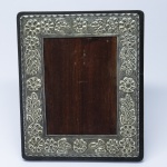 DIVERSOS - Porta retrato em madeira e moldura em metal espessurado a prata. Med. 22x22 cm.