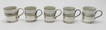 DIVERSOS - Conjunto de 5 xícaras de café com suporte em metal espessurado a prata. Xícara em fina porcelana branca com borda dourada. Med. 5 cm e 9 cm.