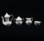COLECIONISMO - Conjunto de miniaturas em porcelana, policromadas, composta de: Bule, jarra, açucareiro, jarra e caneca, decorado com vaquinha.