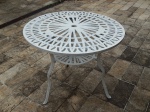 Mesa de jardim em metal pintado de branco, tampo e prateleira inferior redondos e vazados, 3 pés, parte central com encaixe para guarda sol. Alt. 69 x Diam. 83cm.