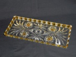 Porta-rocambole em cristal translúcido com detalhes em âmbar, lapidação ao fundo de frisos e estrelados, borda ondulada e denteada. 34 x 15cm.