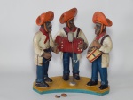 AMARO RODRIGUES (Arte popular, Brasil, século XX) - Escultura em barro cozido policromado representando trio de forró. Mão de um dos músicos quebrada. Assinatura na base. 19 x 19cm.