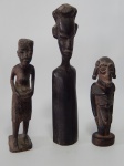Três esculturas africanas esculpidas em madeira representando figuras. Alts. 13 - 16 e 20cm.