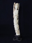KUAN-YIN - Deusa da Misericórdia, esculpida em marfim. Base de madeira entalhada e vazada. Alt. do marfim 31cm e total 35cm.