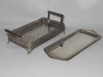 Duas peças em metal prateado: a) Bandeja com laterais vazadas, alças roliças. 29 x 16cm. b) Bandeja para rocambole, borda moldada. 33 x 14cm.