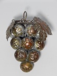 Escultura representando cacho de uvas em metal dourado, parte superior com argola para pendurar. Alt. 15cm.