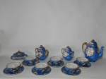 Serviço para chá em antiga porcelana chinesa, fundo azul claro, aplicado com cenas de policromia, detalhes em douração. Composto por 10 peças: bule, leiteira, açucareiro, manteigueira e 6 xícaras com pires. Marcado por selo ao fundo. Tampa do bule com quebrado e colado interno, manteigueiro com bicado na borda. Alt. bule 20cm; xícara 5 x 13cm.