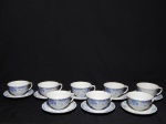 PORCELANA REAL - Oito xícaras e pires para chá em porcelana nacional branca, decoração azul de folhagens e cena de vila ao centro. Marcada no fundo. 7 x 13cm.