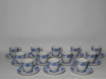 PORCELANA REAL - Doze (12) xícaras e pires para café em porcelana nacional branca, decoração azul de folhagens e cena de vila ao centro. Marcada no fundo. 6 x 11cm.