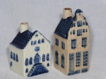 DELFTWARE - Duas garrafas holandesas da bebida Rynbende confeccionadas em porcelana branca e azul moldadas na forma de casas. Oferecidas como souvenir pela companhia aérea holandesa KLM. Abertas e sem tampa. Alt. 9 e 7cm.