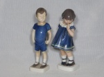 COPENHAGEN - Duas esculturas em porcelana dinamarquesa branca e azul representando um casal de crianças. Uma marcada B&G e uma marcada DJ. Década de 50. Alt. 20cm