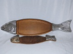 Duas travessas para peixe em madeira. Extremidades aplicadas com cabeça e rabo de bagre em metal prateado. Sutis riscos na madeira. 88 x 22cm e 53 x 13cm.