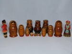 Sete peças em madeira tradicionais russas: Duas bonecas matrioska (incompletas), três porta condimentos na forma de bonecas e duas figuras em trajes típicas esculpidas. Algumas peças no estado Alt. 8, 10 e 11cm